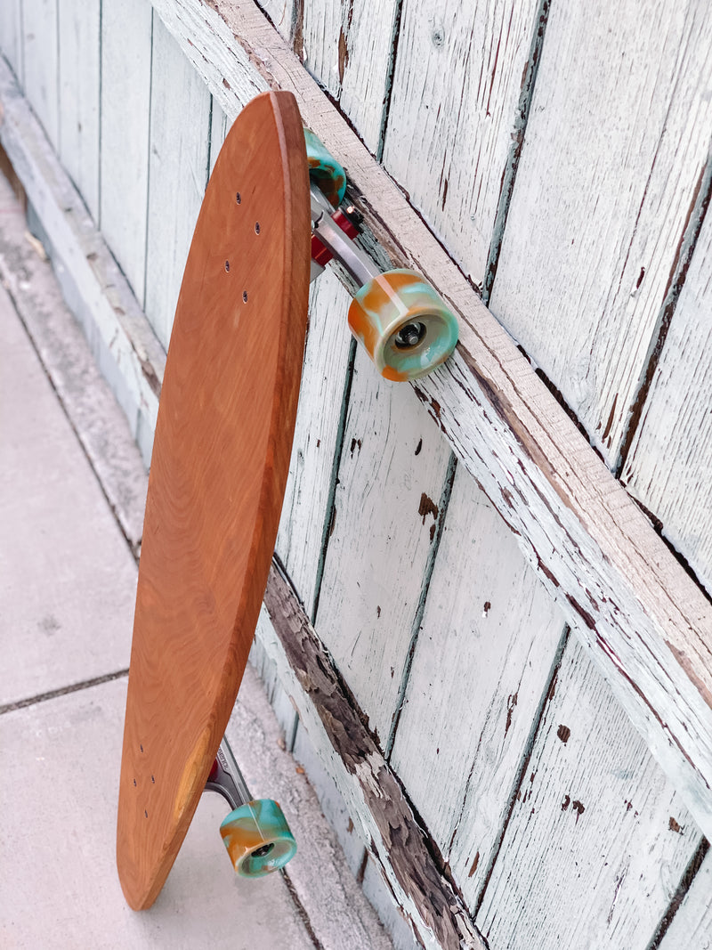 The Nui Pintail Longboard (orange/blue wheels)
